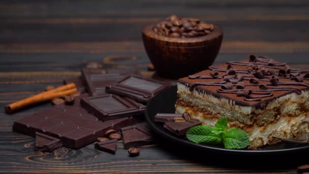 Portie traditioneel Italiaans Tiramisu dessert en stukjes chocoladereep — Stockvideo