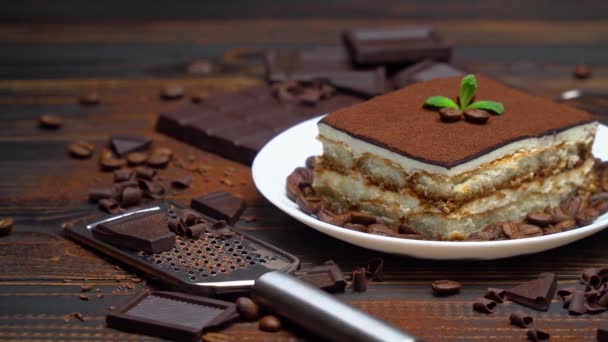 Portie traditioneel Italiaans Tiramisu dessert en stukjes chocoladereep — Stockvideo