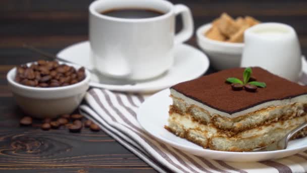 Porcja tradycyjnego włoskiego deseru Tiramisu, filiżanka espresso, mleko, brązowy cukier i kawa — Wideo stockowe