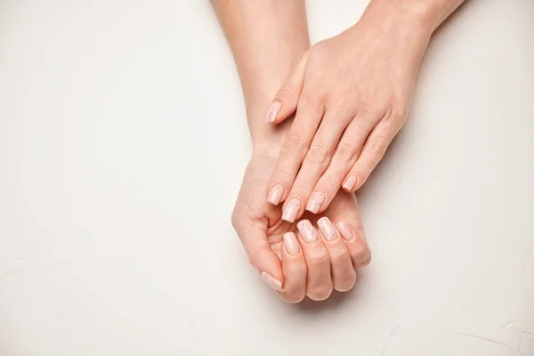 Mãos de mulher com bela manicure no fundo claro — Fotografia de Stock