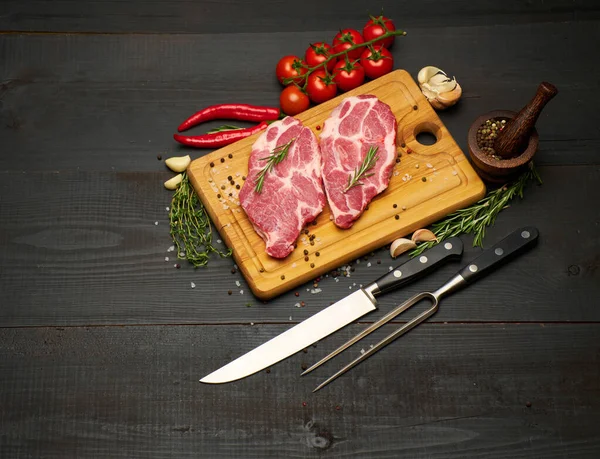 Taze çiğ et ya da ahşap kesme tahtasındaki domuz bifteği. — Stok fotoğraf