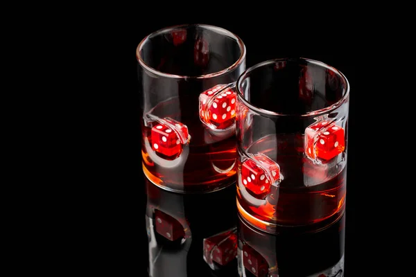 Whisky glazen met rum of whiskey met rode dices op donkere glazen ondergrond — Stockfoto
