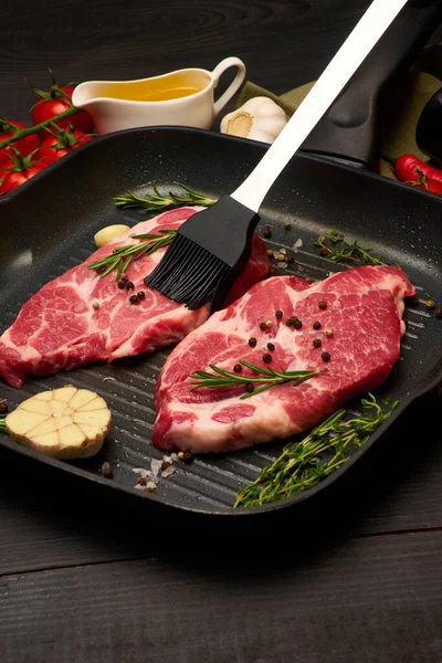 Fresh raw beef or pork steaks on frying pan — Stock Photo, Image