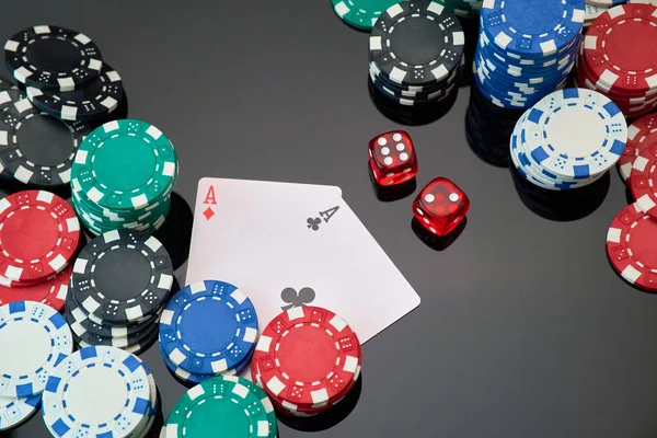 Casino chips, playing cards and dices on dark reflective background — Stock Photo, Image