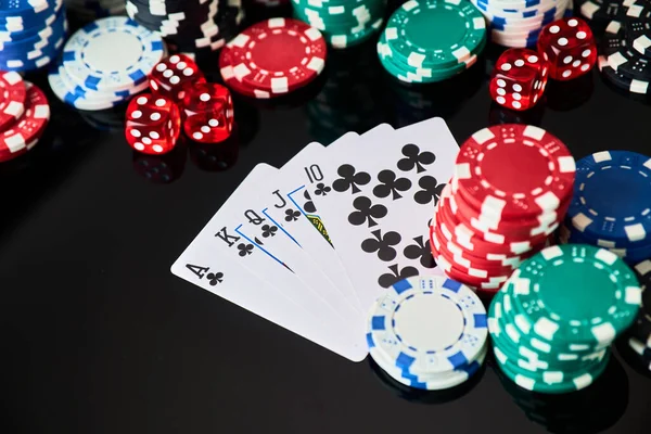 Casino chips, playing cards and dices on dark reflective background — Stock Photo, Image