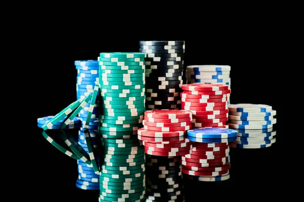 Stack of Casino gambling chips isolated on black reflective background — Stock Photo, Image