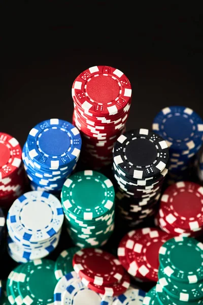 Stack of Casino gambling chips isolated on black reflective background — Stock Photo, Image