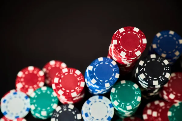 Stack of Casino gambling chips isolated on black reflective background — Stock Photo, Image