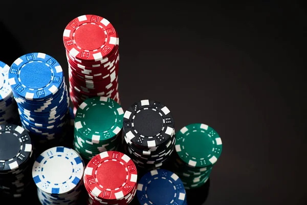 Stack of Casino gambling chips isolated on black reflective background — Stock Photo, Image