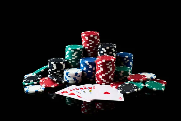 Stack of Casino gambling chips and cards isolated on black reflective background — Stock Photo, Image