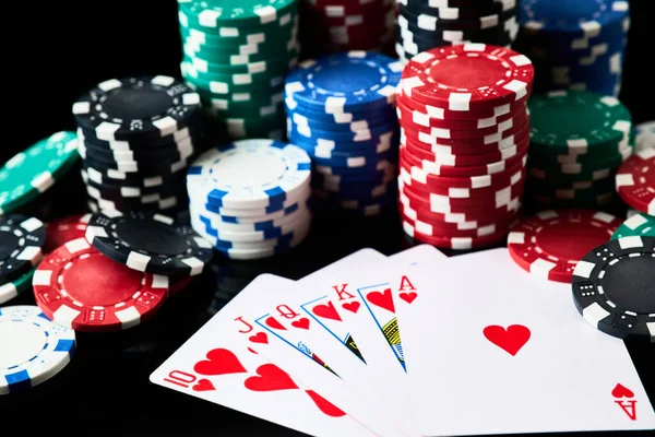 Stack of Casino spelmarker och kort isolerade på svart reflekterande bakgrund — Stockfoto