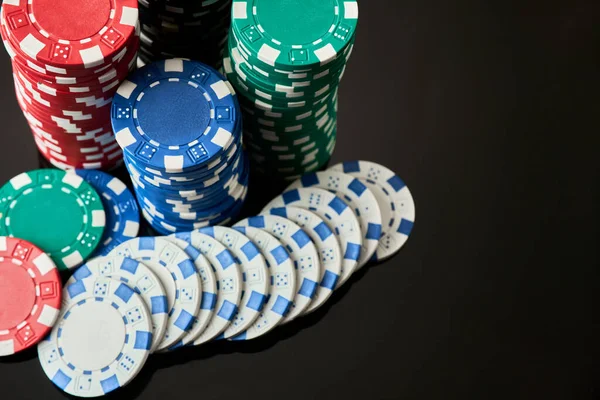 Stack of Casino gambling chips isolated on black reflective background — Stock Photo, Image