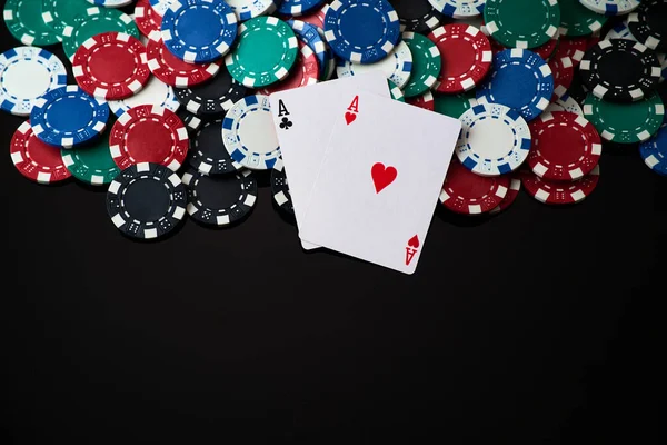Casino chips and playing cards on dark reflective background — Stock Photo, Image