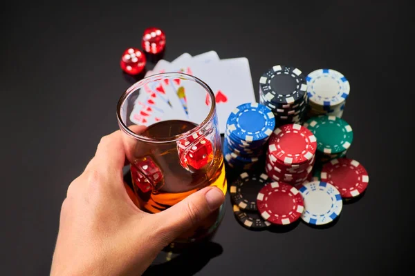 Kasino marker, spelkort, glas whisky och tärningar på mörk reflekterande bakgrund — Stockfoto