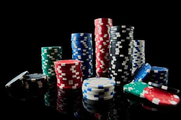Stack of Casino gambling chips isolated on black reflective background — Stock Photo, Image