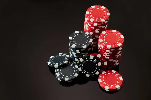 Stack of Casino gambling chips isolated on black reflective background — Stock Photo, Image