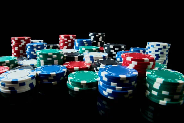 Stack of Casino jetons de jeu isolés sur fond noir réfléchissant — Photo