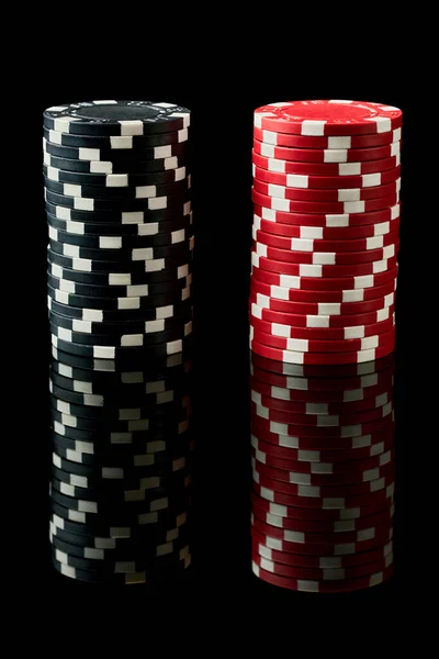 Στοίβα των τσιπ τυχερών παιχνιδιών χαρτοπαικτικών λεσχών που απομονώνονται σε μαύρο ανακλαστικό φόντο — Φωτογραφία Αρχείου