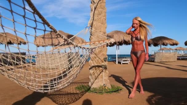 Ung modekvinna i bikini som går på stranden — Stockvideo