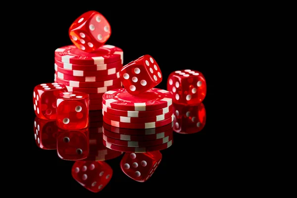 Red casino dice and chips isolated over black reflective background — Stock Photo, Image