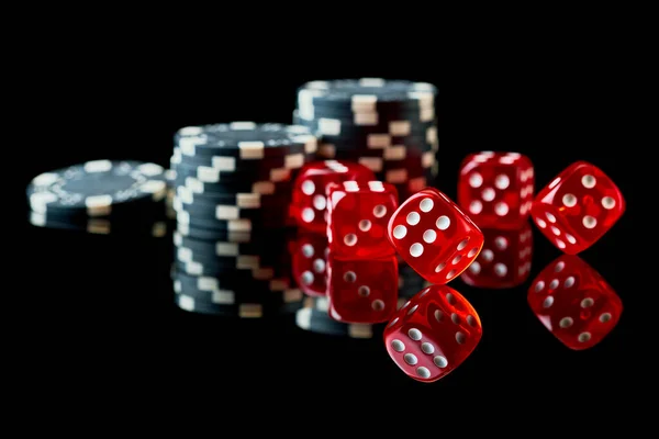 Dados de casino vermelho e fichas isoladas sobre fundo reflexivo preto — Fotografia de Stock