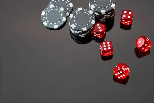 Red casino dice and chips isolated over black reflective background — Stock Photo, Image