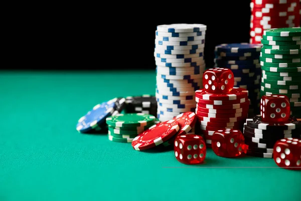 Stack of Casino gambling chips and dices on green table — Stock Photo, Image