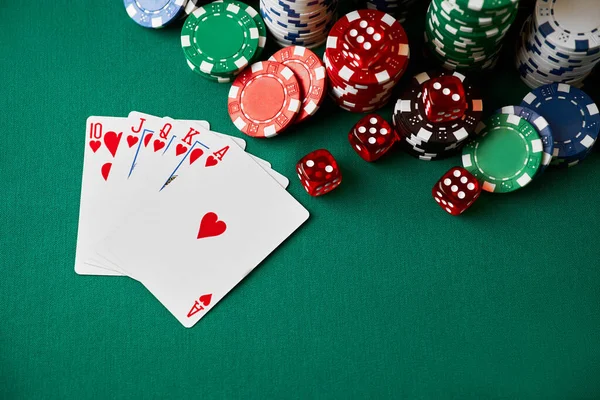 Casino chips, playing cards and dices on green fabric table — Stockfoto
