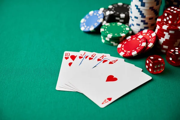 Casino chips, playing cards and dices on green fabric table — Stockfoto