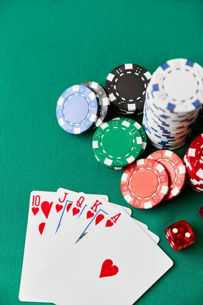 Casino chips, playing cards and dices on green fabric table — Stockfoto
