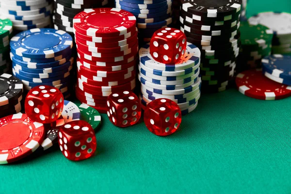 Pile of Casino pocker gambling chips and dices on green table — Stockfoto