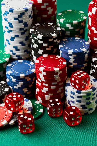 Pile of Casino pocker gambling chips and dices on green table — Stockfoto