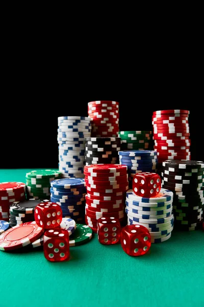 Pile of Casino pocker gambling chips and dices on green table — Stockfoto