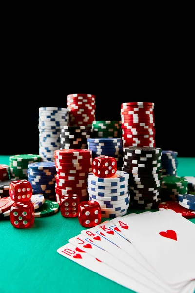Casino chips, playing cards and dices on green fabric table Stock Image