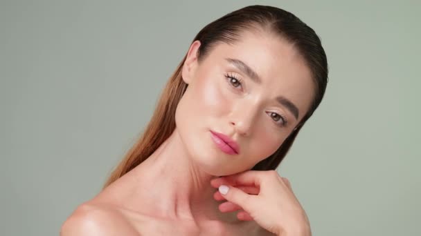 Gyönyörű fiatal nő tiszta friss bőr áll a fény szürke háttér — Stock videók