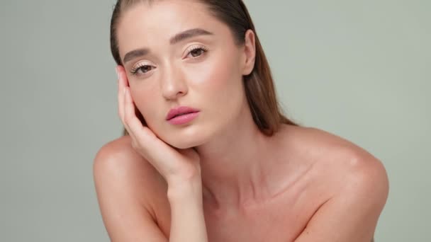 Beautiful Young Woman with Clean Fresh Skin standing over light grey background — Stock Video