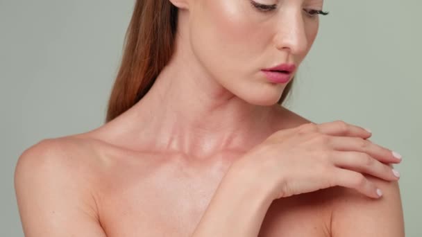 Beautiful Young Woman with Clean Fresh Skin standing over light grey background — Stock Video