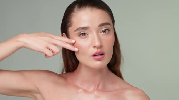 Schöne junge Frau mit sauberer, frischer Haut vor hellgrauem Hintergrund — Stockvideo