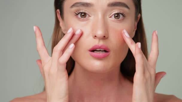 Beautiful Young Woman with Clean Fresh Skin standing over light grey background — Stock Video