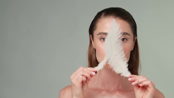 Piękna młoda kobieta z czystą świeżą skórą stojąca na jasnoszarym tle — Wideo stockowe