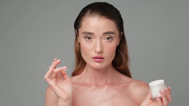 Schöne junge Frau mit sauberer, frischer Haut vor hellgrauem Hintergrund — Stockvideo