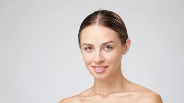 Hermosa mujer joven con piel limpia y fresca de pie sobre fondo gris claro — Vídeos de Stock