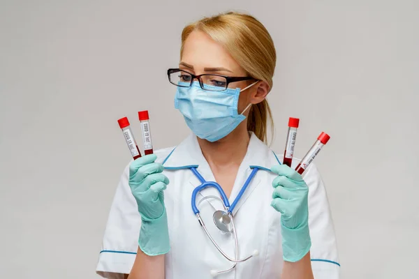 Ärztin Krankenschwester mit Schutzmaske und Handschuhen - im Reagenzglas — Stockfoto