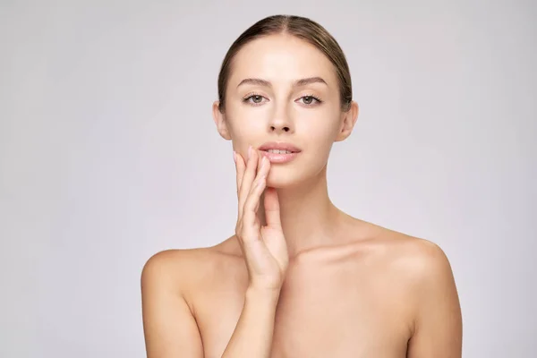 Beautiful Young Woman with Clean Fresh Skin standing over light grey background — Stock Photo, Image