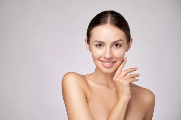 Vacker ung kvinna med ren fräsch hud står över ljusgrå bakgrund — Stockfoto