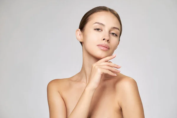 Schöne junge Frau mit sauberer, frischer Haut vor hellgrauem Hintergrund — Stockfoto