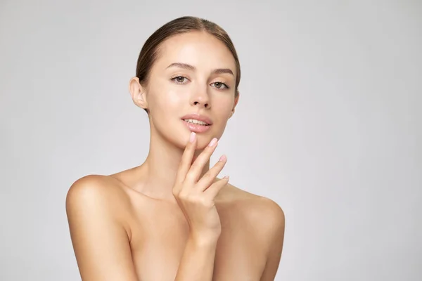 Bella giovane donna con pelle fresca pulita in piedi su sfondo grigio chiaro — Foto Stock