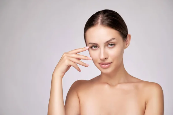 Bella giovane donna con pelle fresca pulita in piedi su sfondo grigio chiaro — Foto Stock