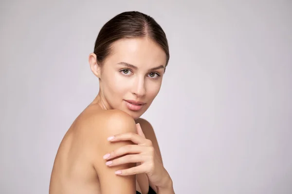 Belle jeune femme avec peau fraîche propre debout sur fond gris clair — Photo