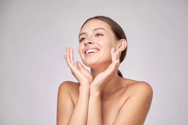 Mooie jonge vrouw met schone frisse huid staande over lichtgrijze achtergrond — Stockfoto